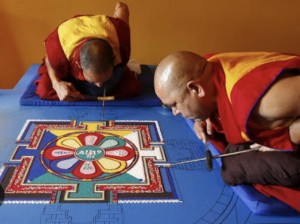 Monaci che creano mandala di sabbia